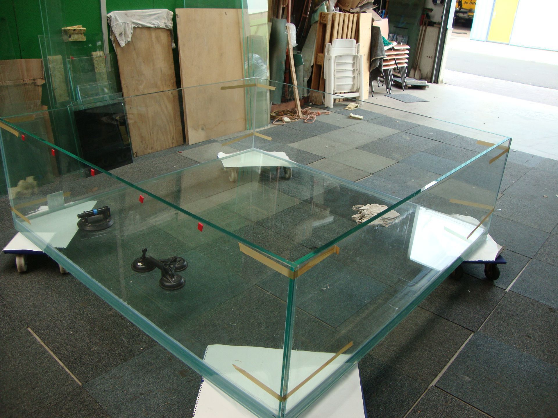 Op een tegelvloer staat een groot glazen aquarium