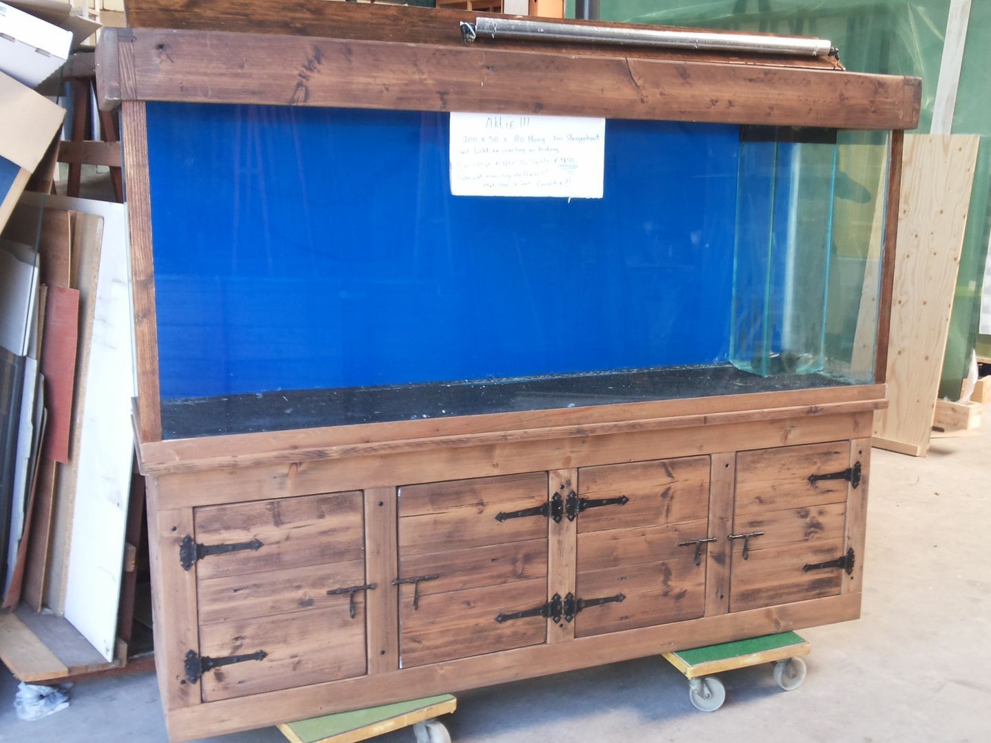 Een groot houten aquarium met een blauwe achtergrond