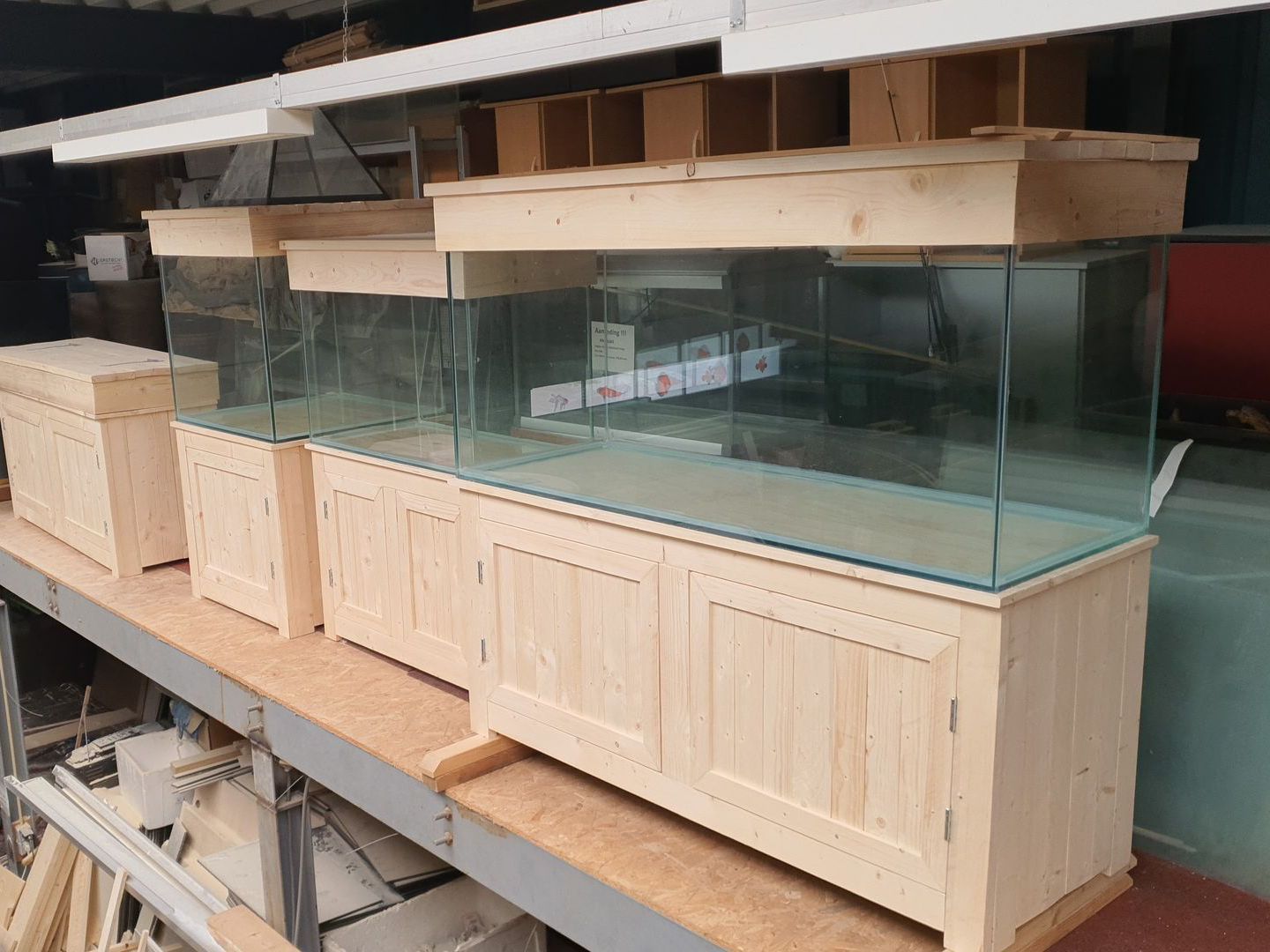 Op een houten plank staat een houten aquarium.