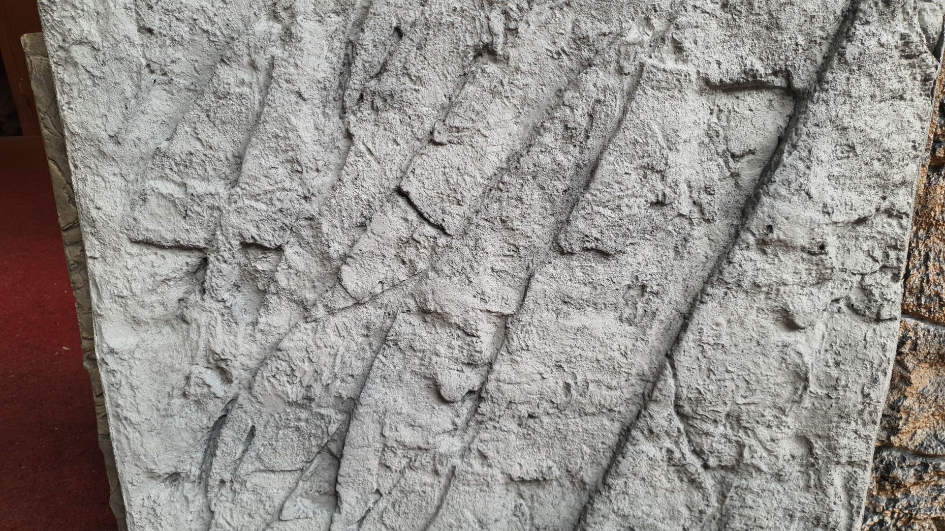 Een close-up van een stuk beton op een rode loper.