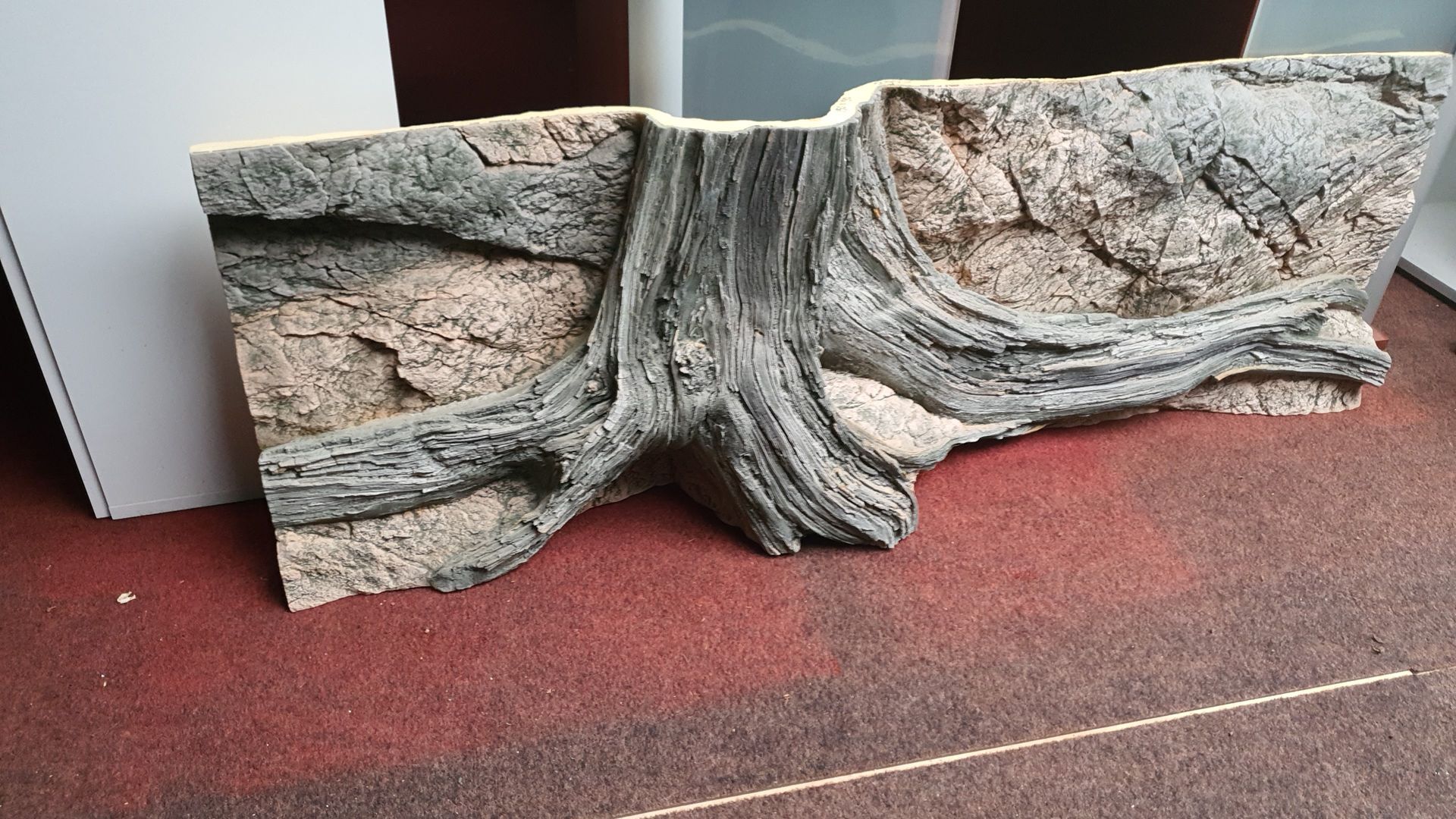 Een stuk hout ligt op een rode loper