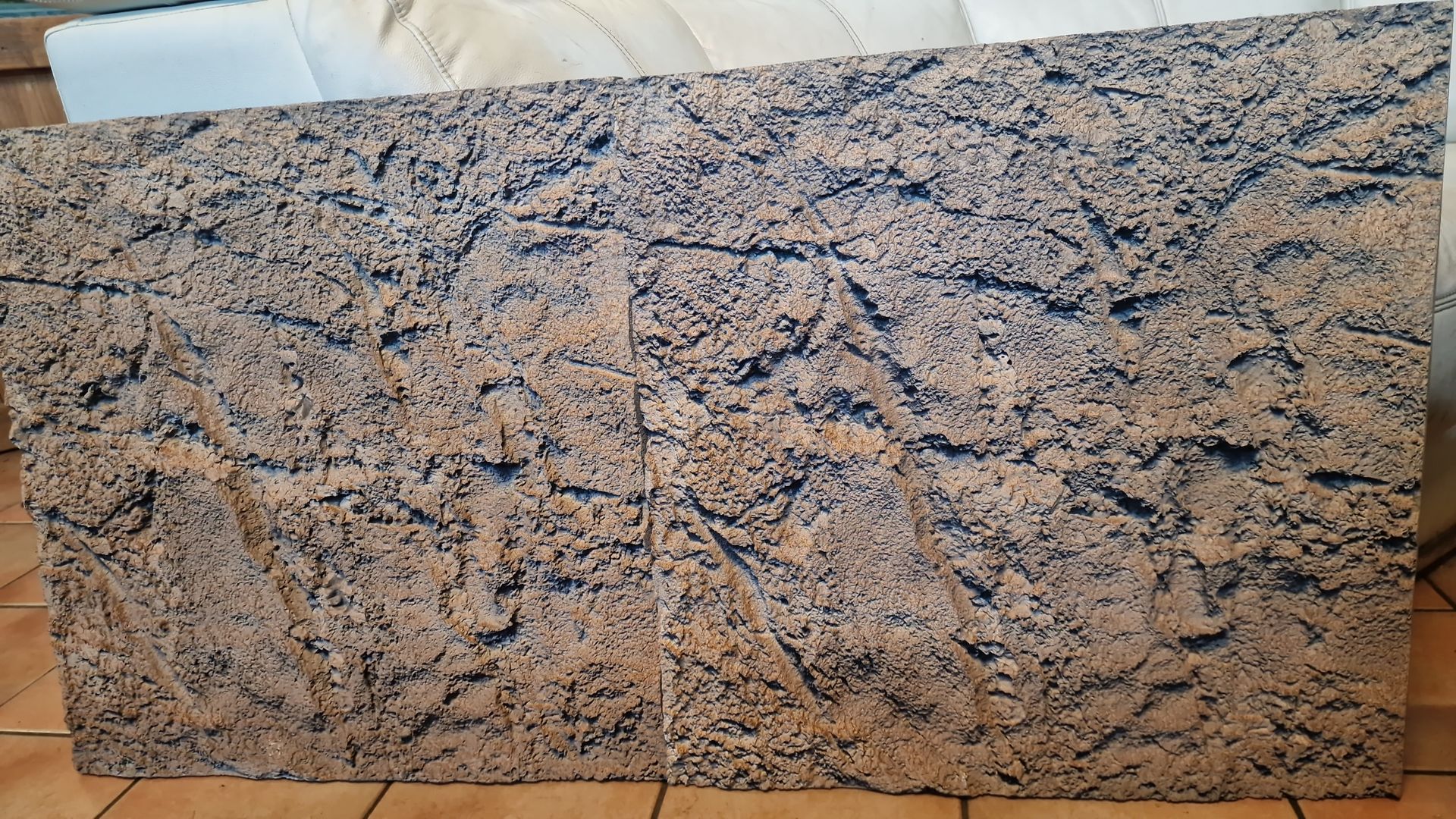 Op een houten vloer ligt een groot stuk graniet