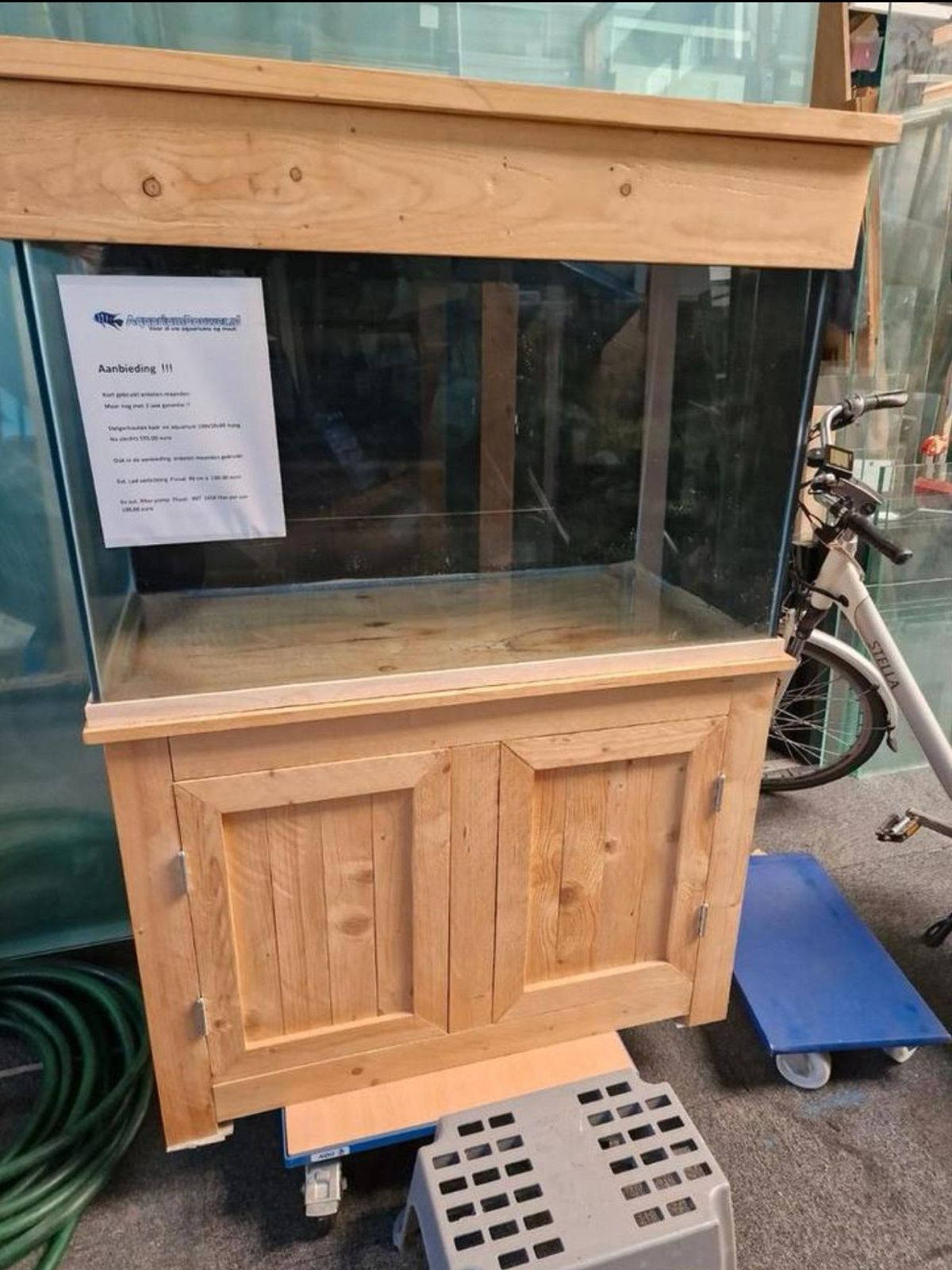 In een kamer met tegelvloeren staat een groot aquarium.
