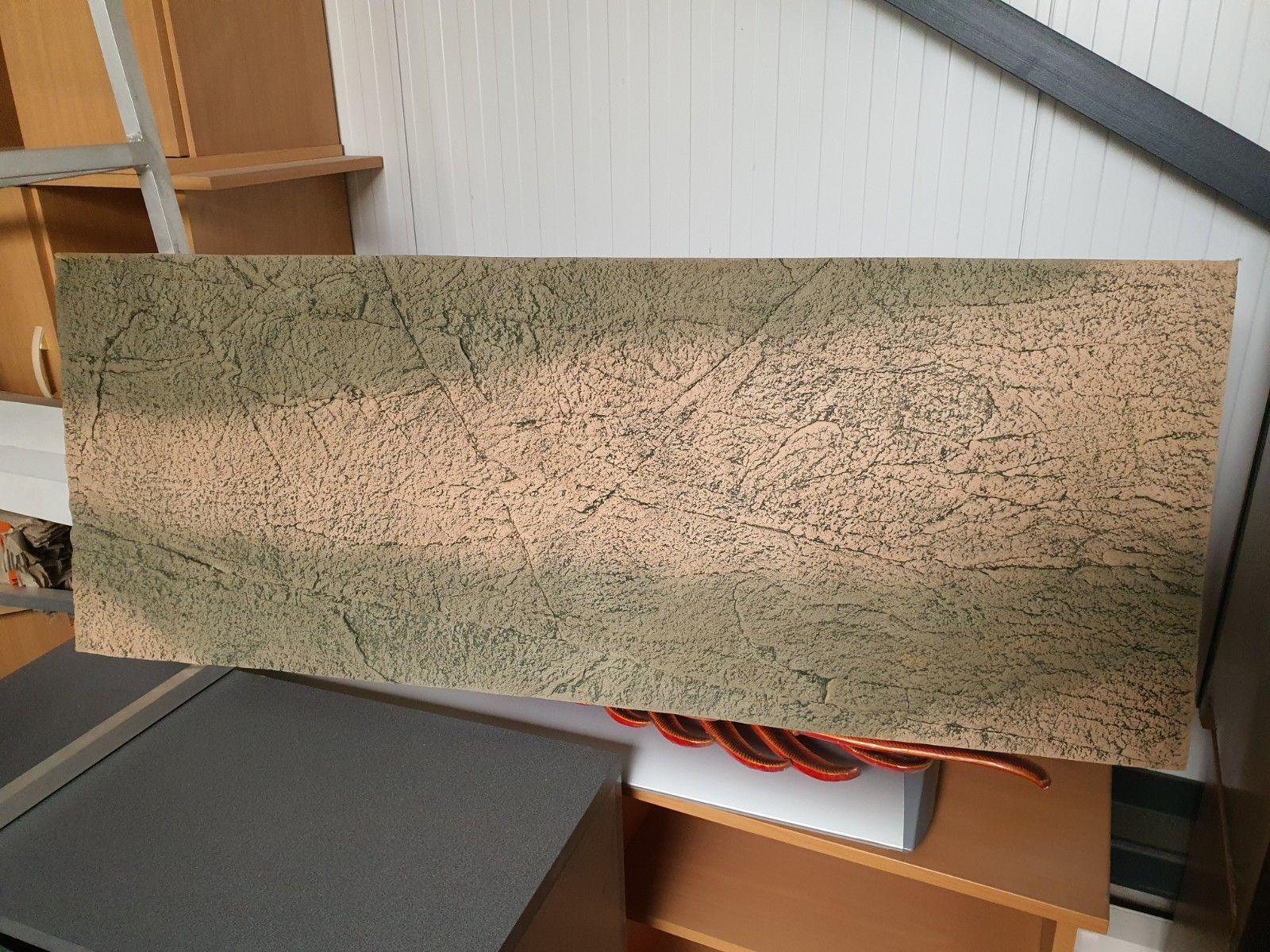 Op een plank ligt een stuk hout.