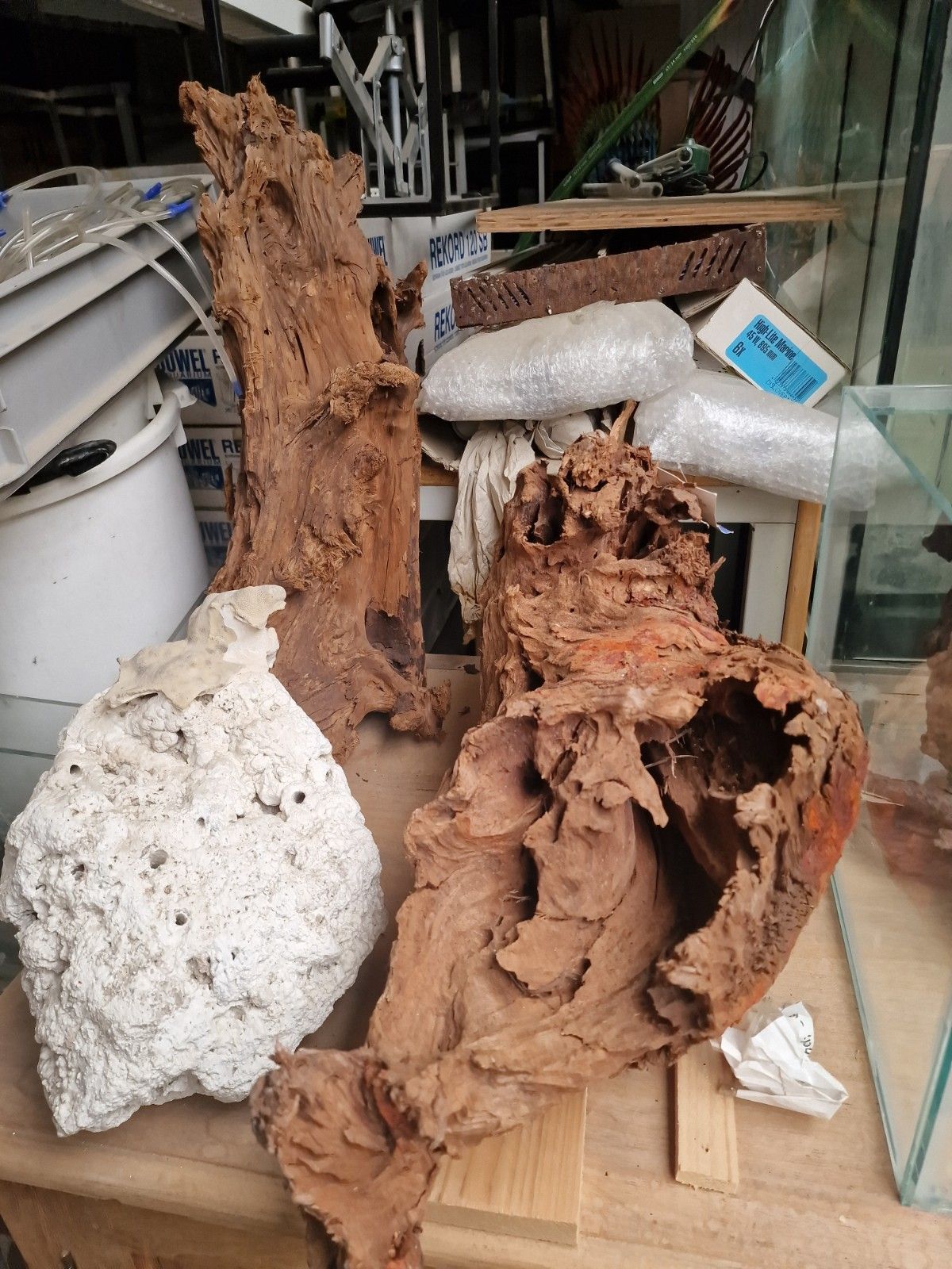 Op een tafel ligt een stapel hout en stenen.