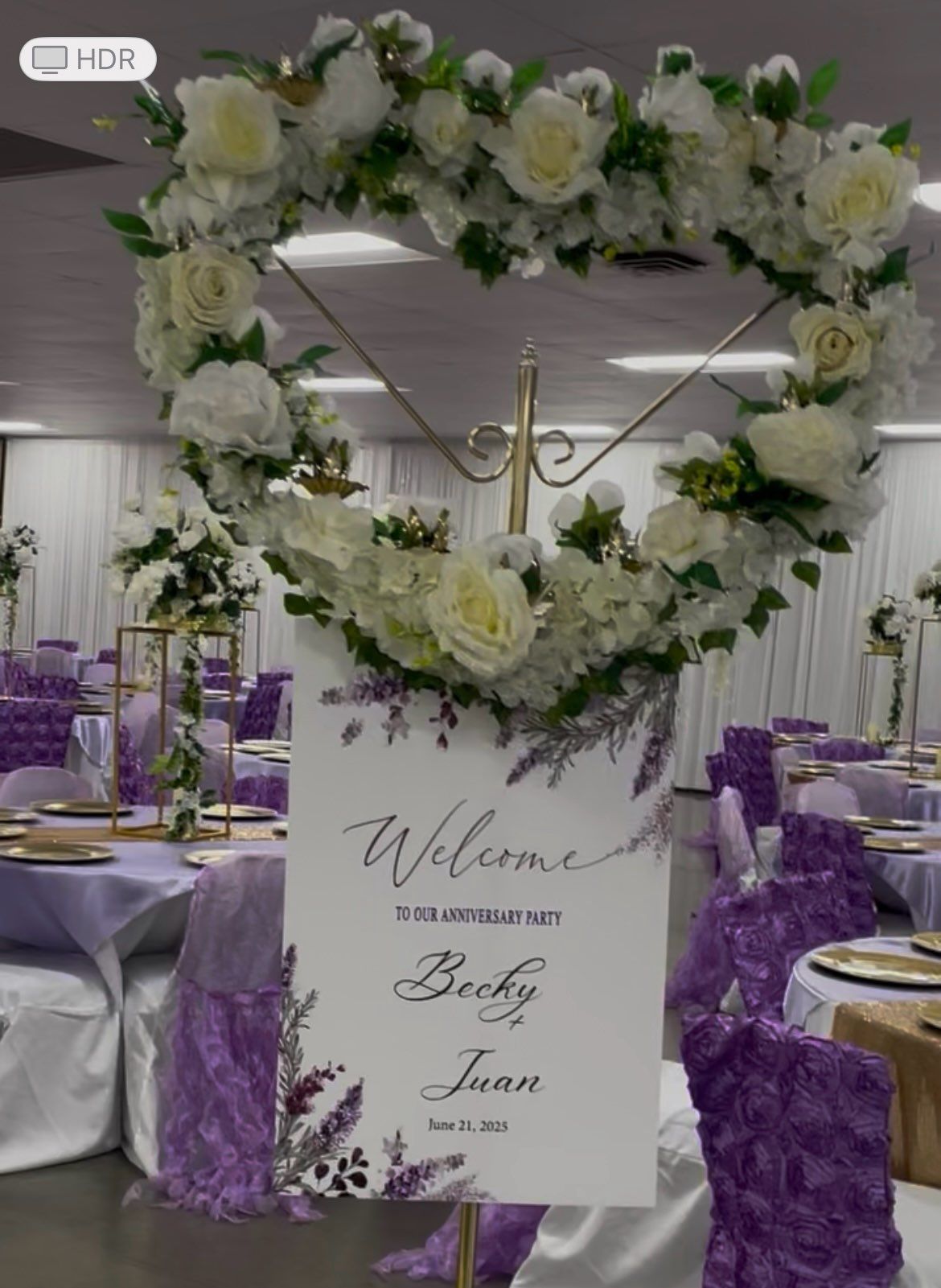 Wedding reception with floral heart arch, welcome sign for Becky and Juan, purple decor.
