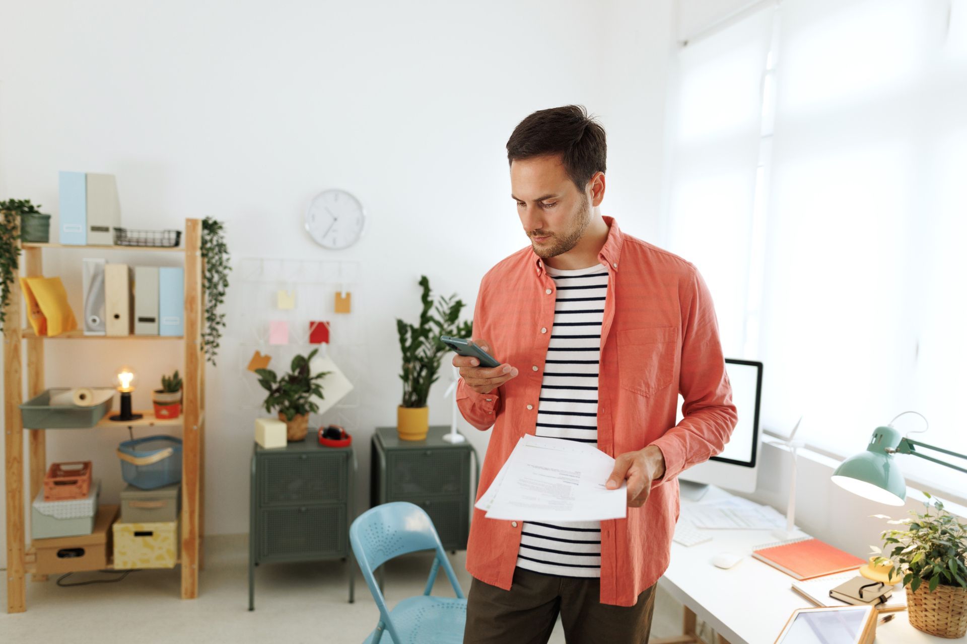 A Man Is Standing and Holding a Piece of Paper and Looking at His Phone | Sydney, NSW | Online Divorce Australia