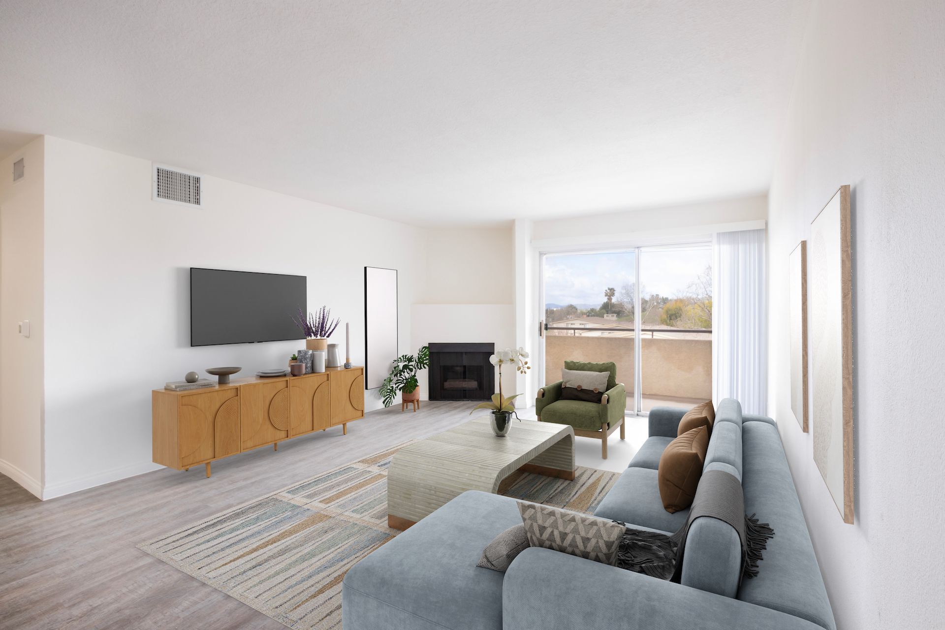 Spacious living room with light blue sofa, wooden cabinet, and sliding glass door to a balcony.