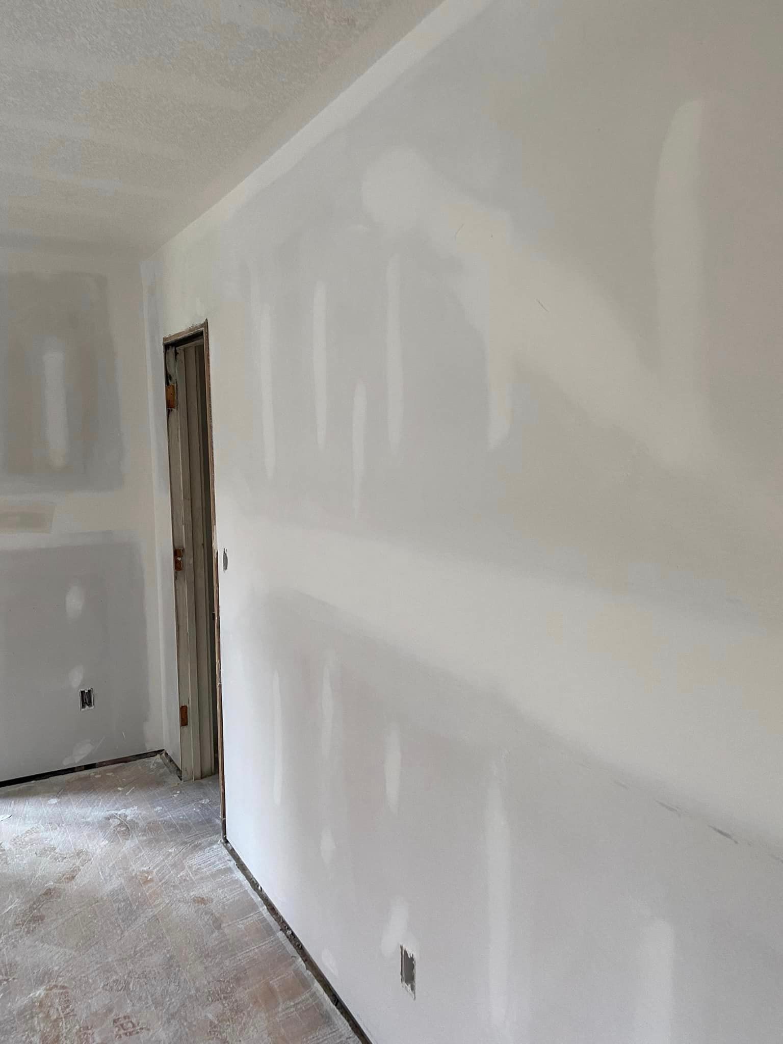A room with drywall walls and a door.