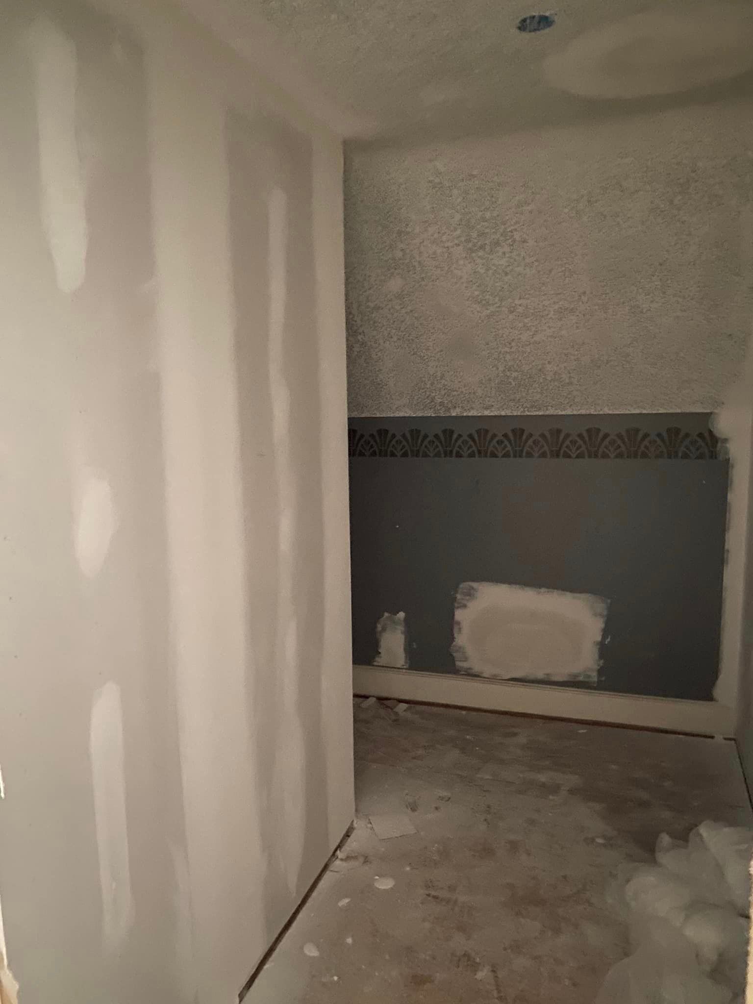 A room with drywall walls and a gray wall.