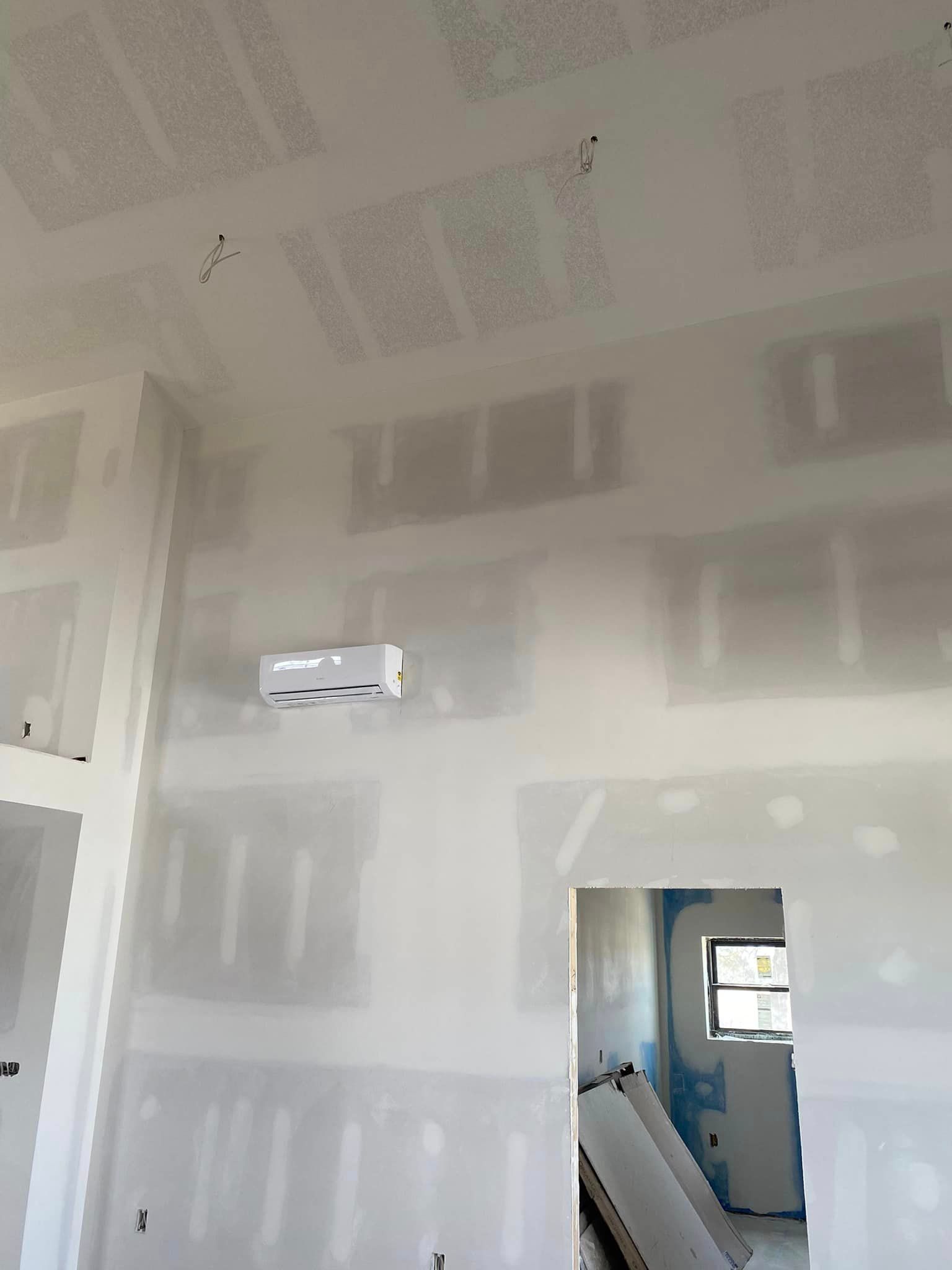 A room with drywall walls and a ceiling fan.