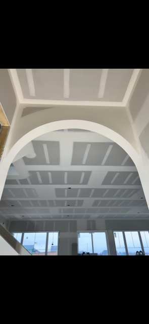 A room with a ceiling that is being built and a window.