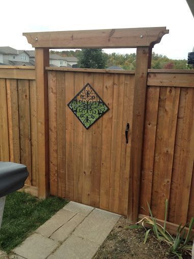 A wooden fence with a gate and a sign on it.