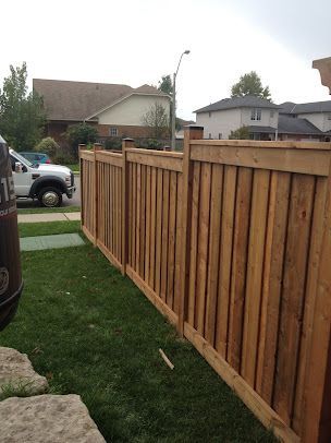 A wooden fence with a white truck parked behind it