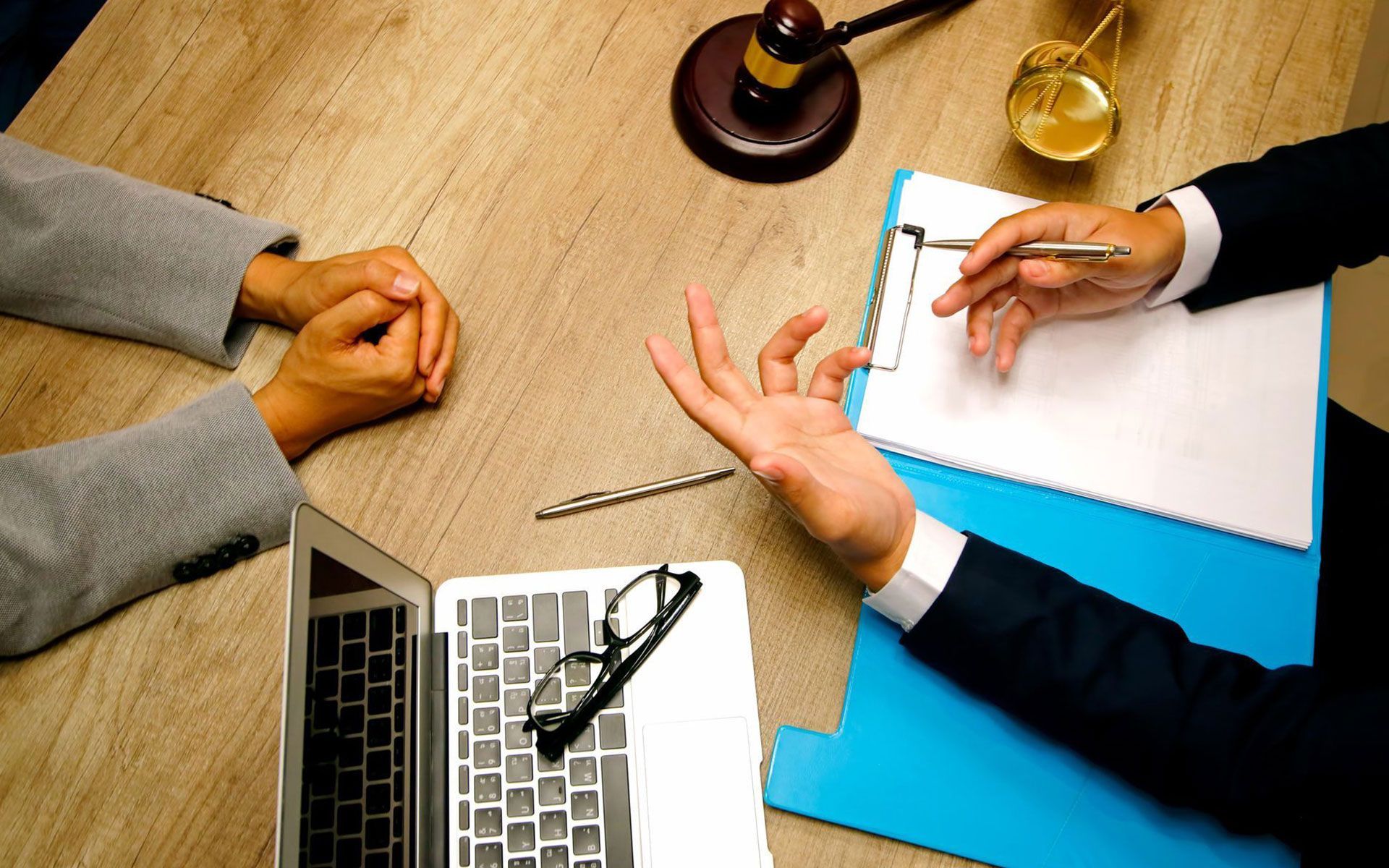 A man and a woman are sitting at a table with a laptop.