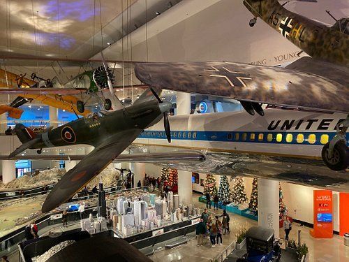 A united airlines plane is hanging from the ceiling of a museum.