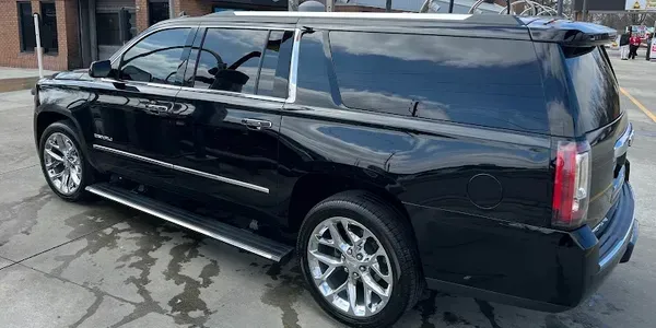 A black suv is parked in a parking lot in front of a building.