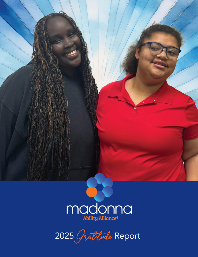 Two smiling people in front of a blue background. The Madonna logo and 