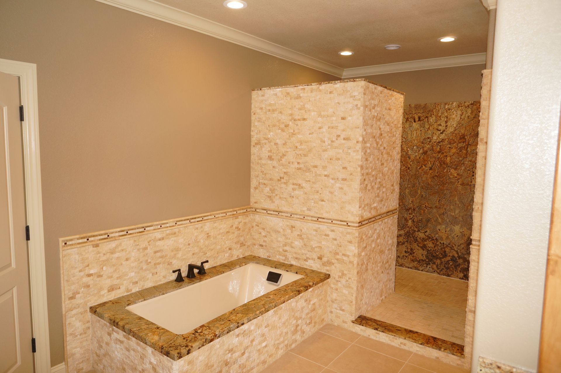 A bathroom with a tub , sink , mirror and walk in shower.