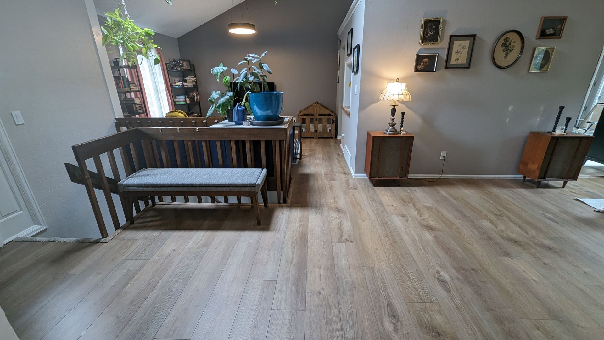 A living room with luxury vinyl floors and a bench.