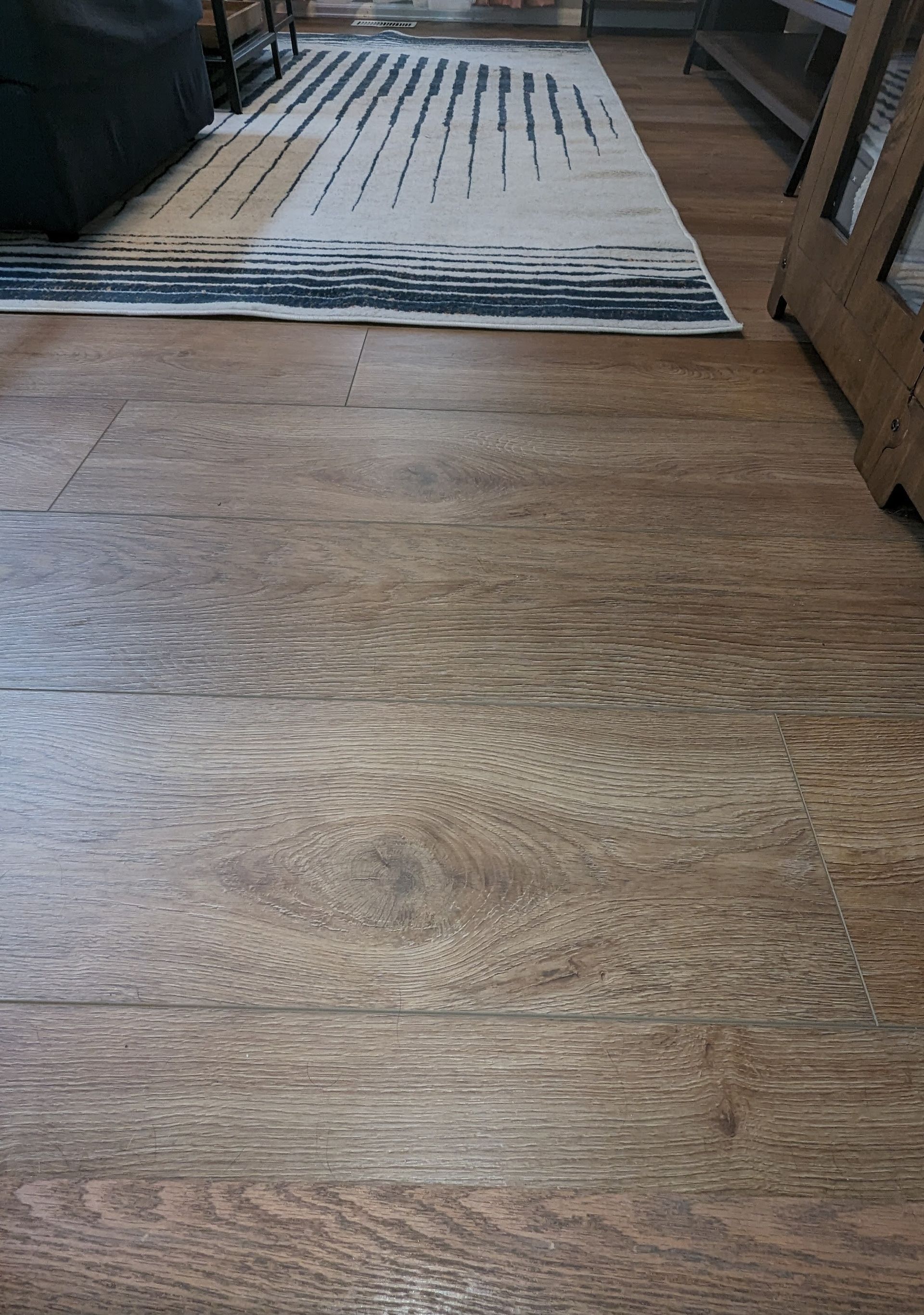 A wooden floor with a rug on it in a living room.