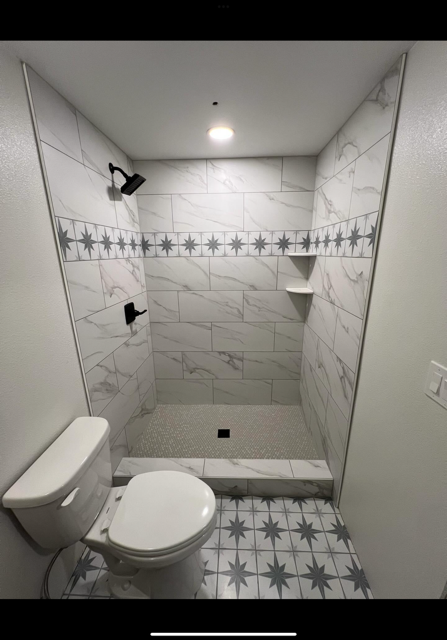 A bathroom with a toilet and a walk in shower