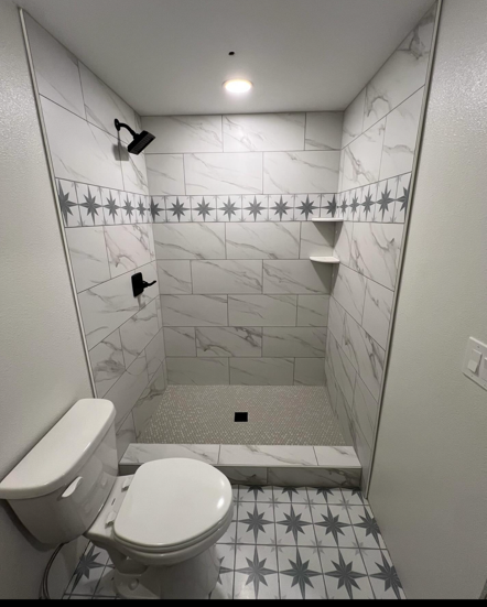 A bathroom with a toilet and a walk in shower