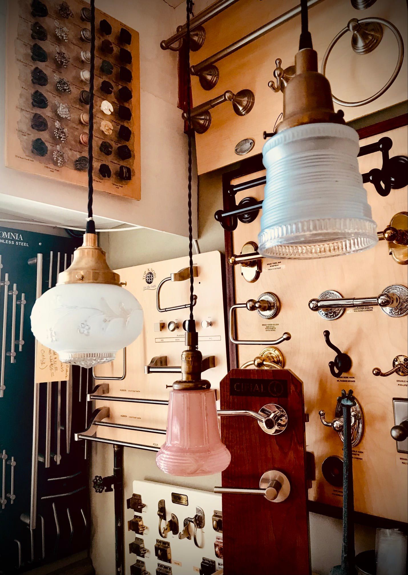 Antique light fixtures and hardware displayed in a shop, showcasing various styles and designs.