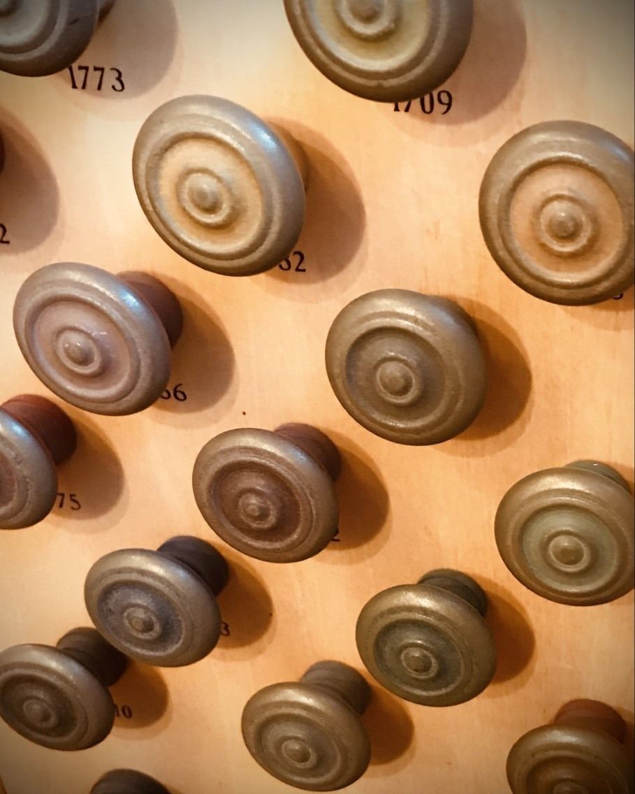 Wooden knobs on a board, each with a central circle design, labeled with numbers.