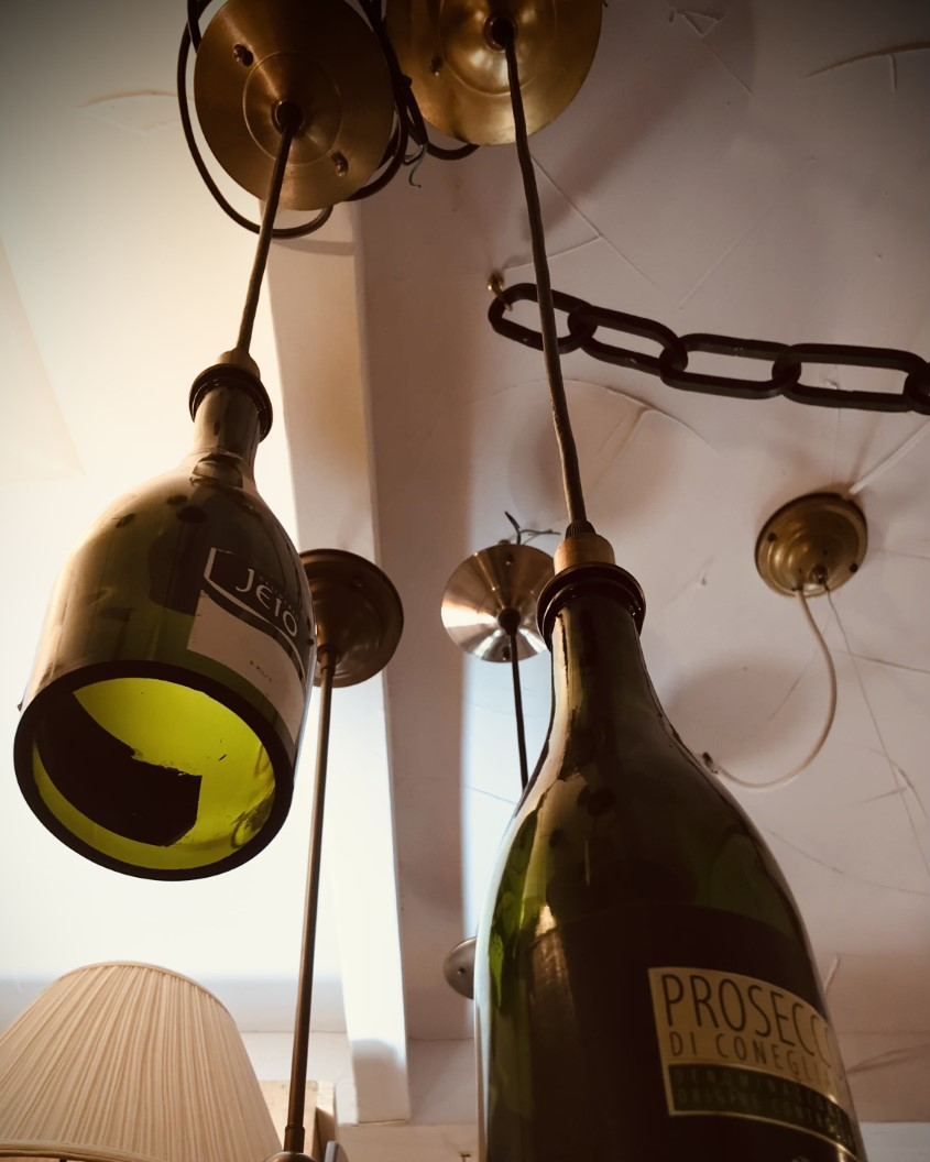 Champagne bottle pendant lights hanging from a ceiling.
