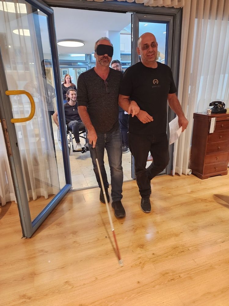 שני גברים הולכים דרך פתח אל תוך חדר מואר עם רצפות עץ