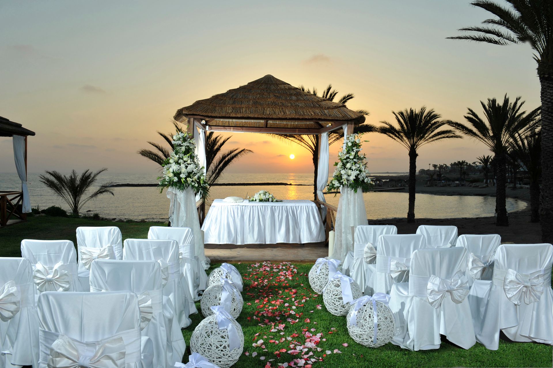Weddings. A bride and groom holding hands on the beach at sunset