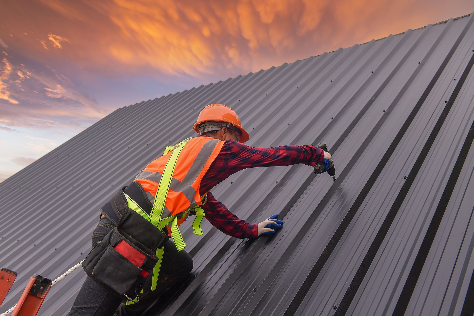 Residential metal roof installation with standing seam gray metal panels on a home.