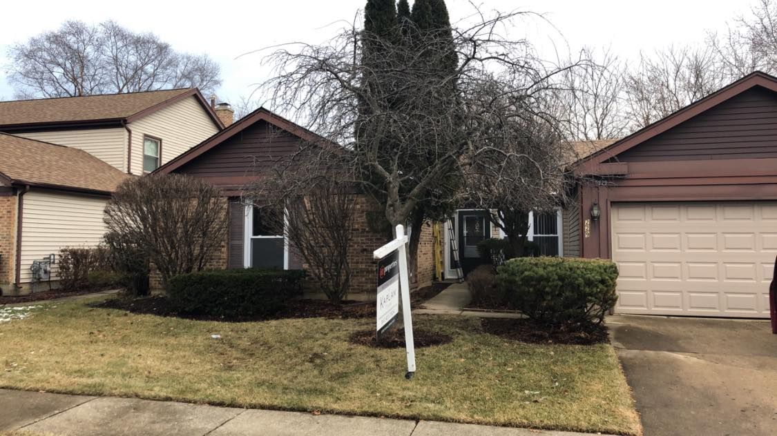 A brown-sided house with a garage and a 