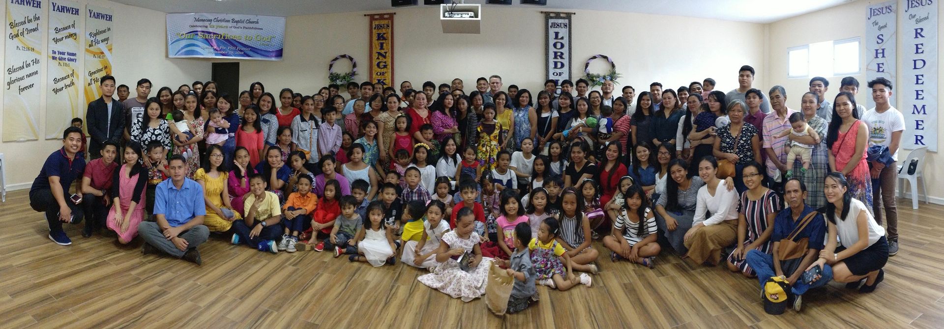 A large group of people are posing for a picture in a room.