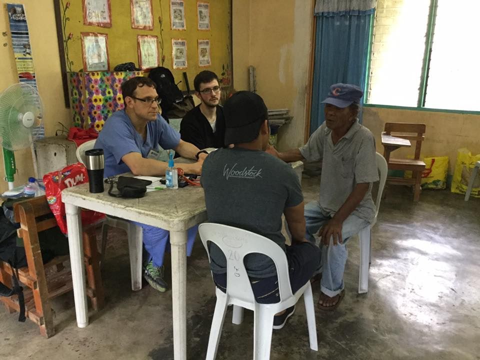 A group of people are sitting around a table in a room.