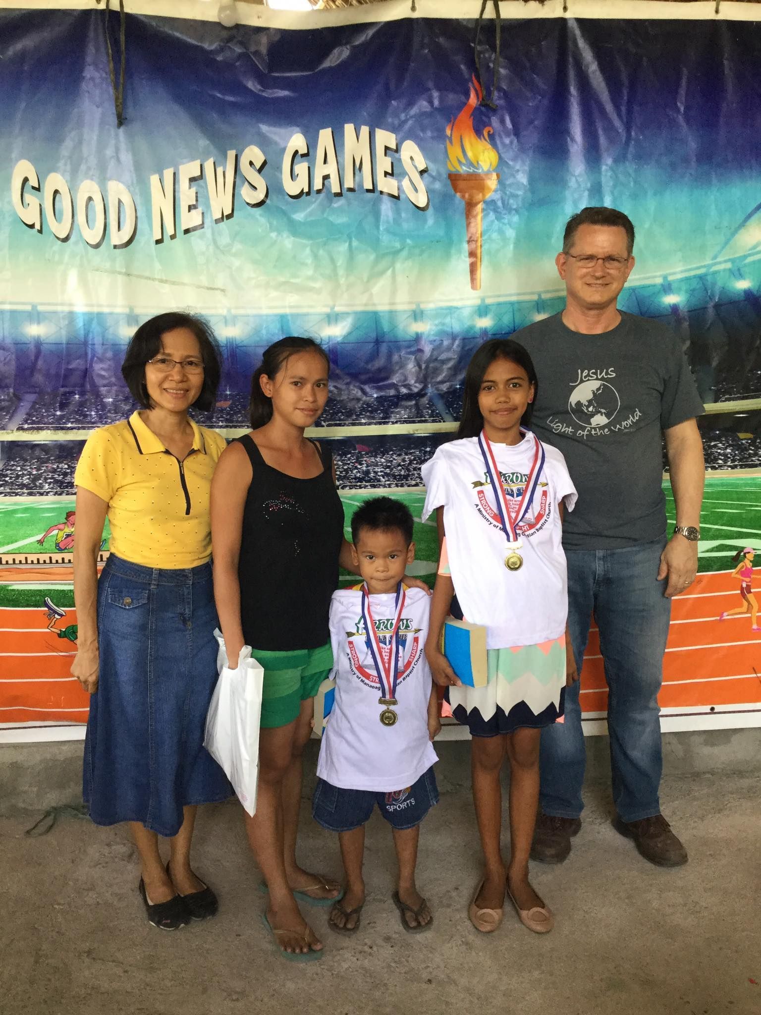 A group of people standing in front of a sign that says good news games