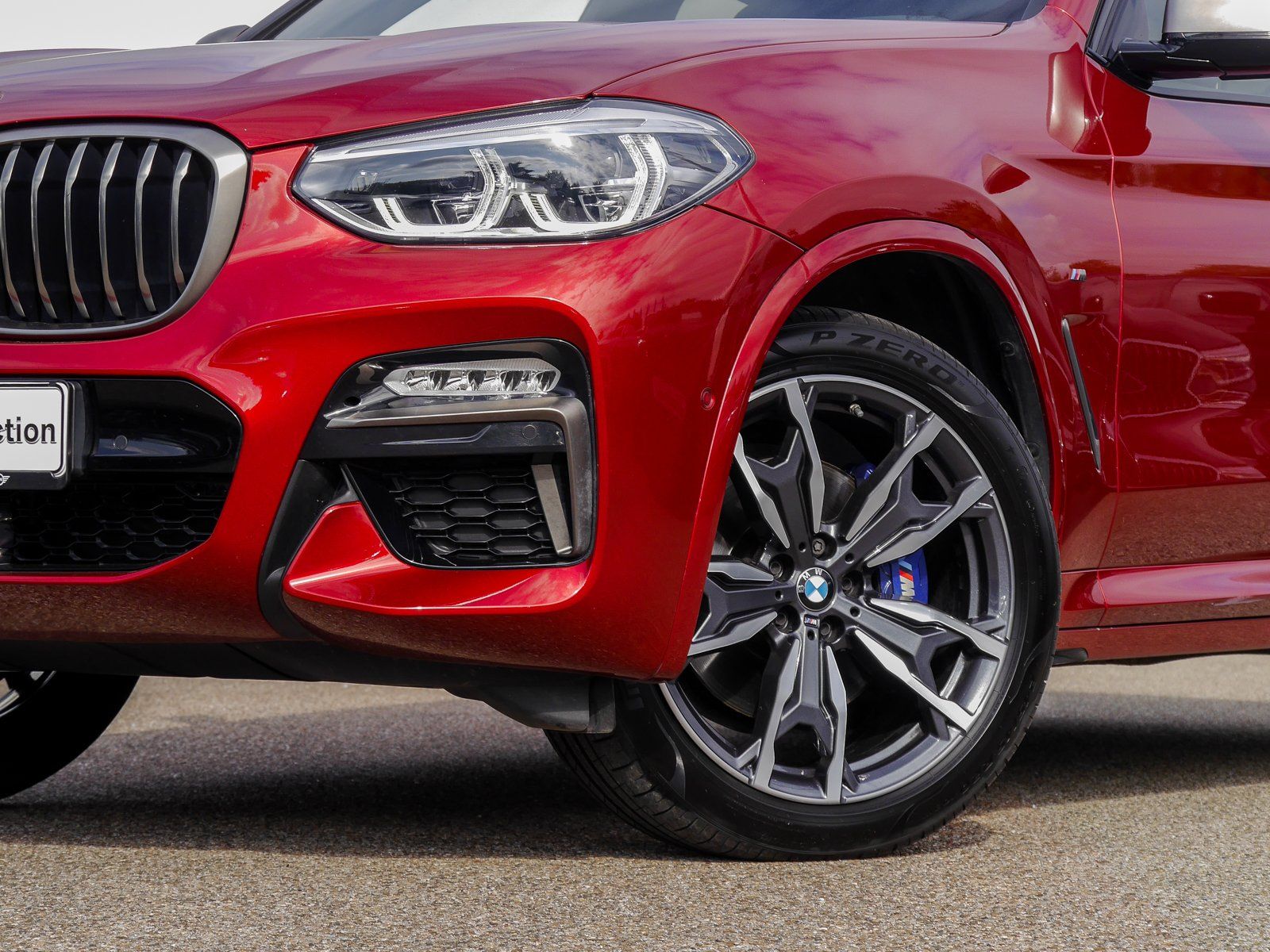 Am Straßenrand parkt ein roter BMW X4.