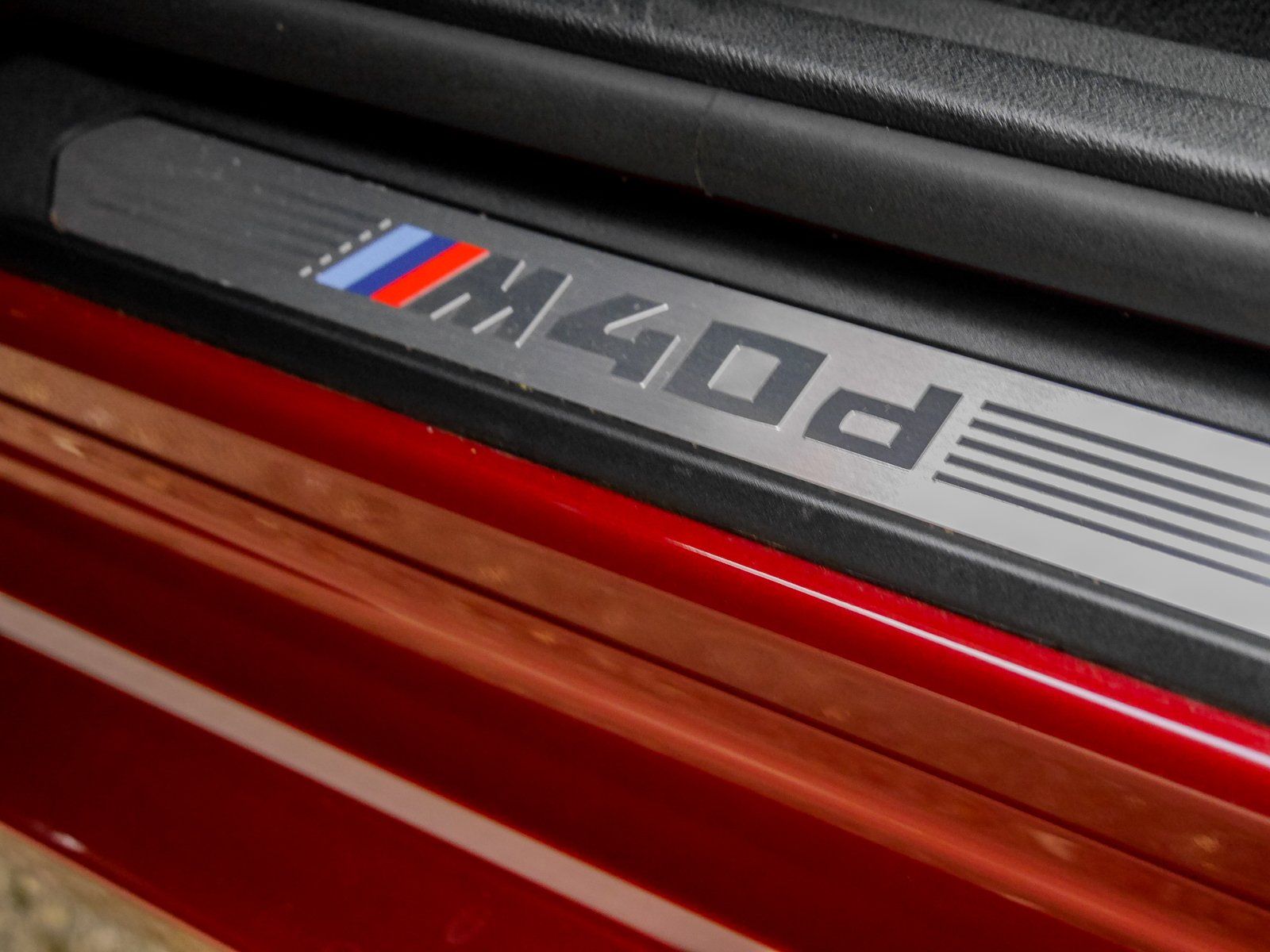 Ein rotes Auto mit einem BMW-Logo auf der Türschwelle