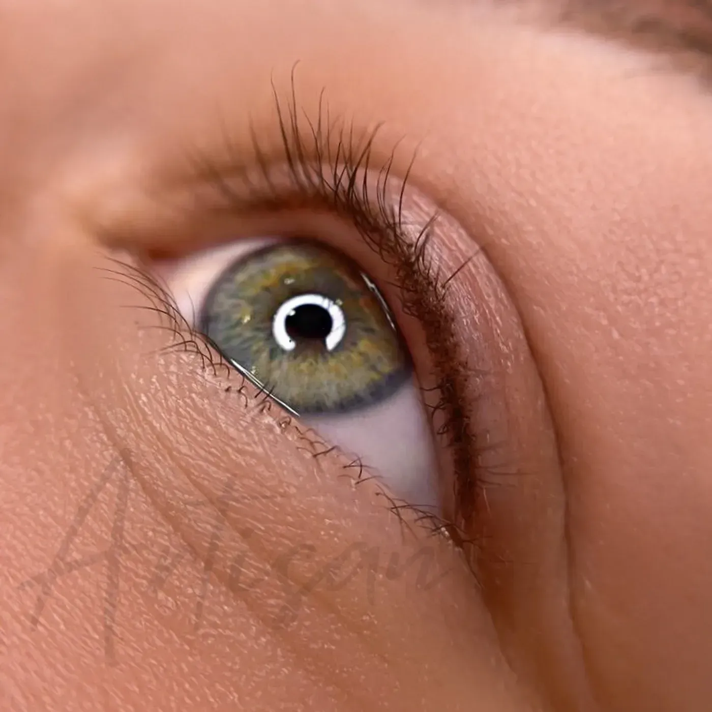 Hazel-green eye with a fine permanent eyeliner tattoo on the upper lash line — Artisan Cosmetic Tattoo, Worongary QLD