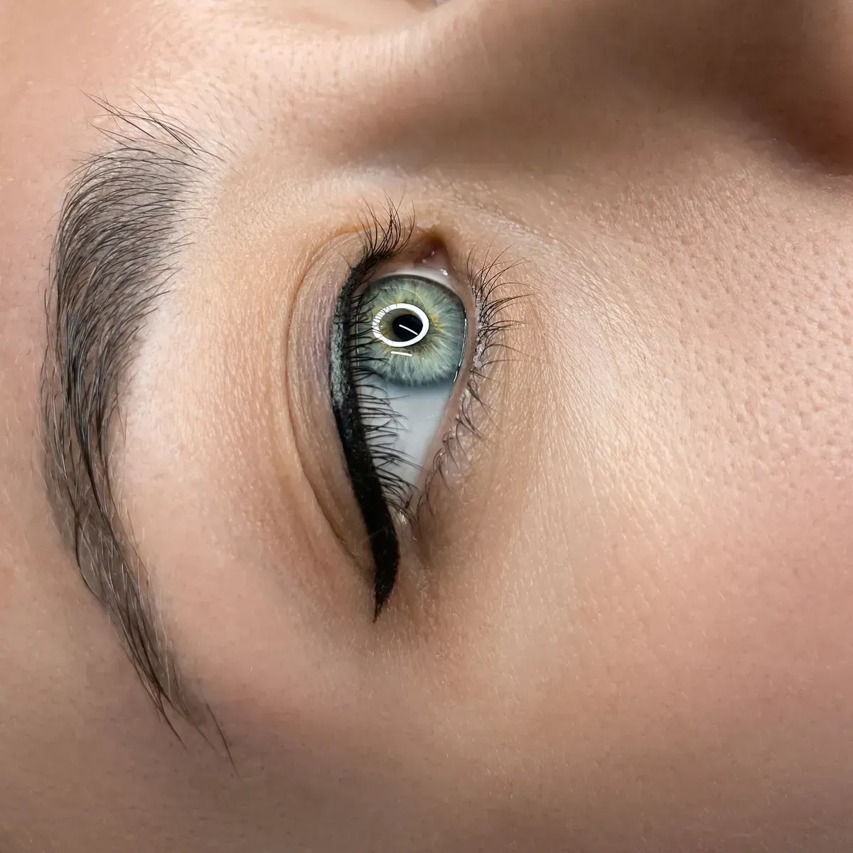 Blue-grey eye with dark eyeliner tattoo along the upper lash line — Artisan Cosmetic Tattoo, Worongary QLD