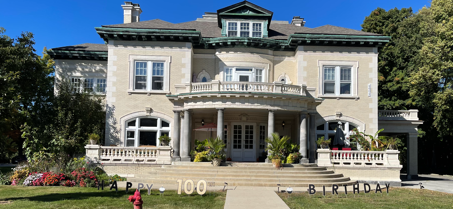 A large white house with a fire hydrant in front of it.