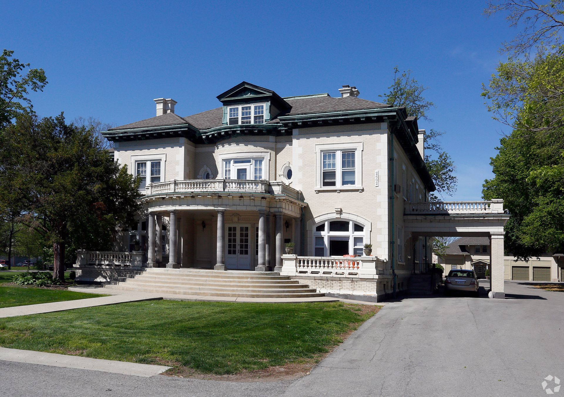 A large house with a car parked in front of it