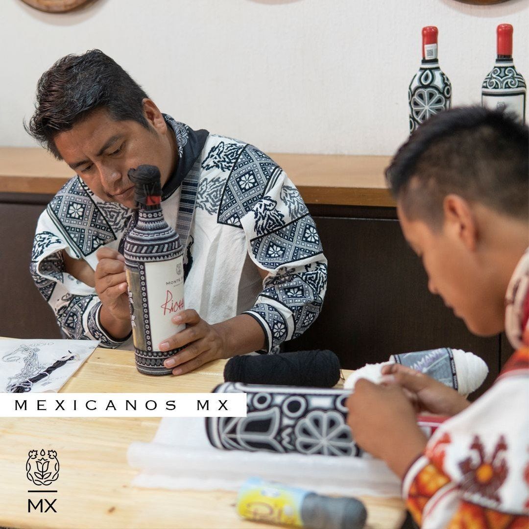 Personas pintando botellas decorativas en una mesa de manualidades, con diseños estampados y materiales de arte.