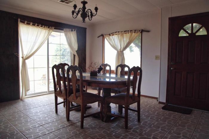 Comedor con mesa y sillas de madera, lámpara de araña
