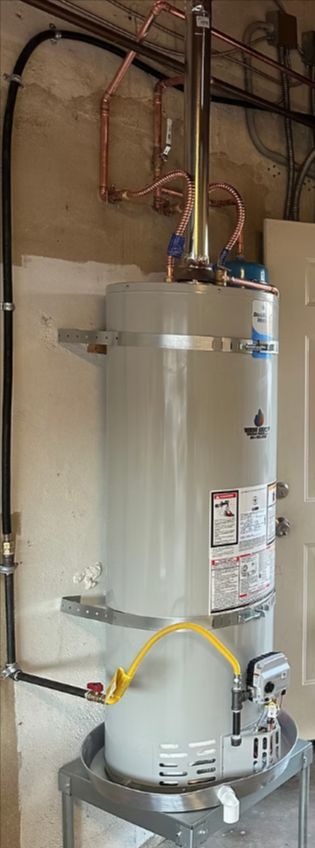 Water heater in a utility closet with exposed copper pipes and a yellow gas line.