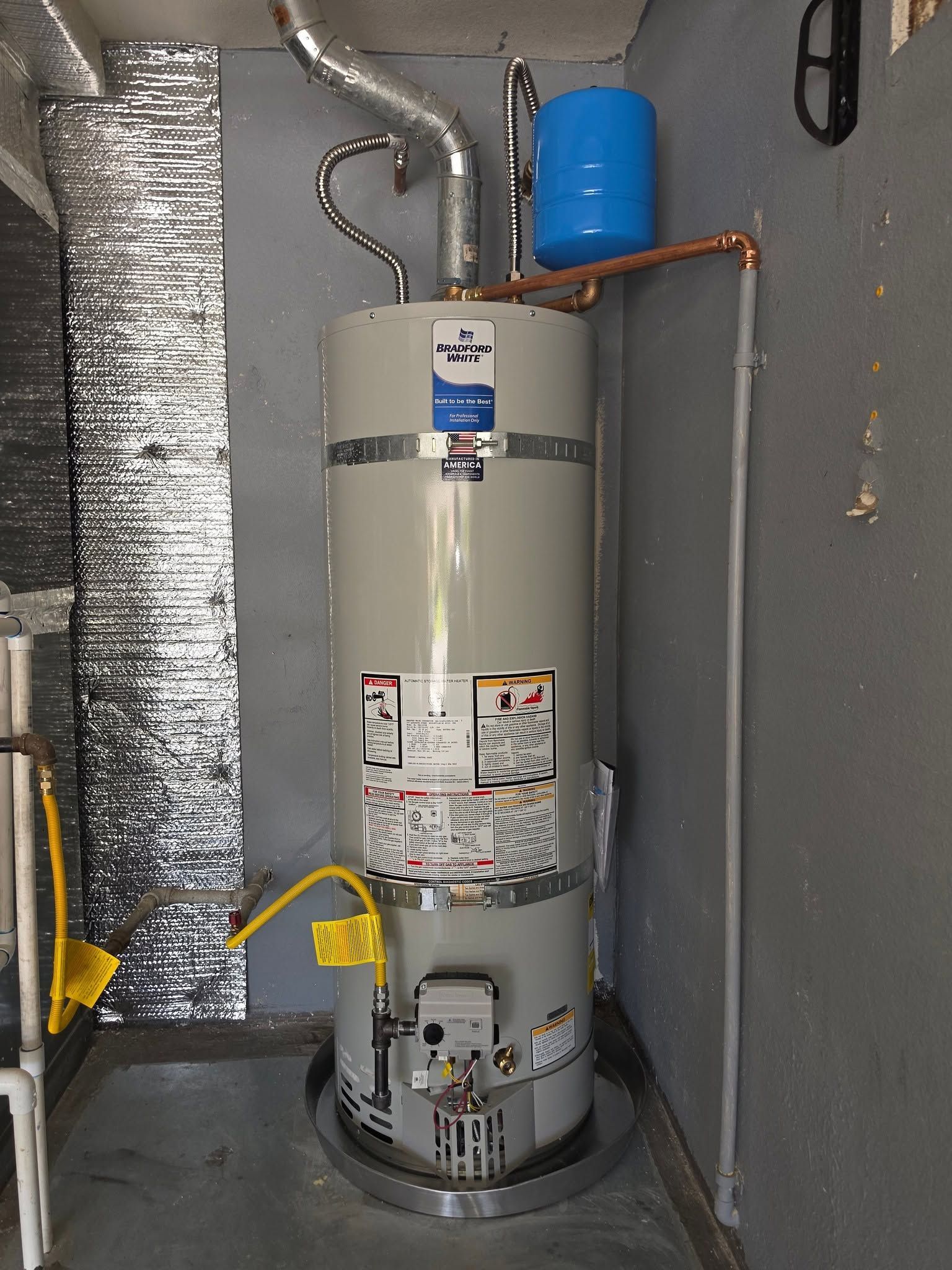 Water heater in a utility closet with exposed pipes, ducting, and a blue expansion tank.