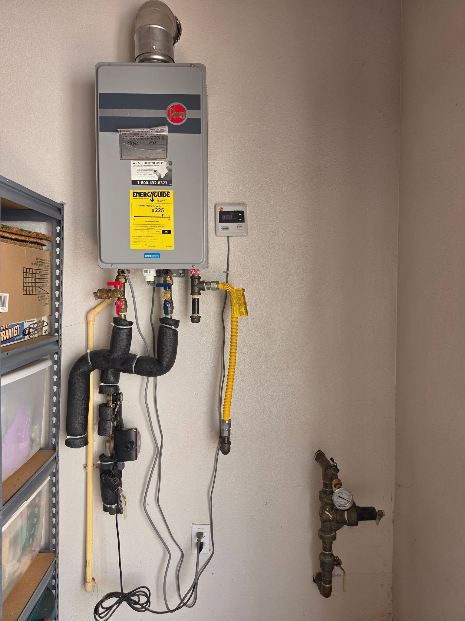 Wall-mounted gas water heater with pipes and shutoff valves in a utility closet