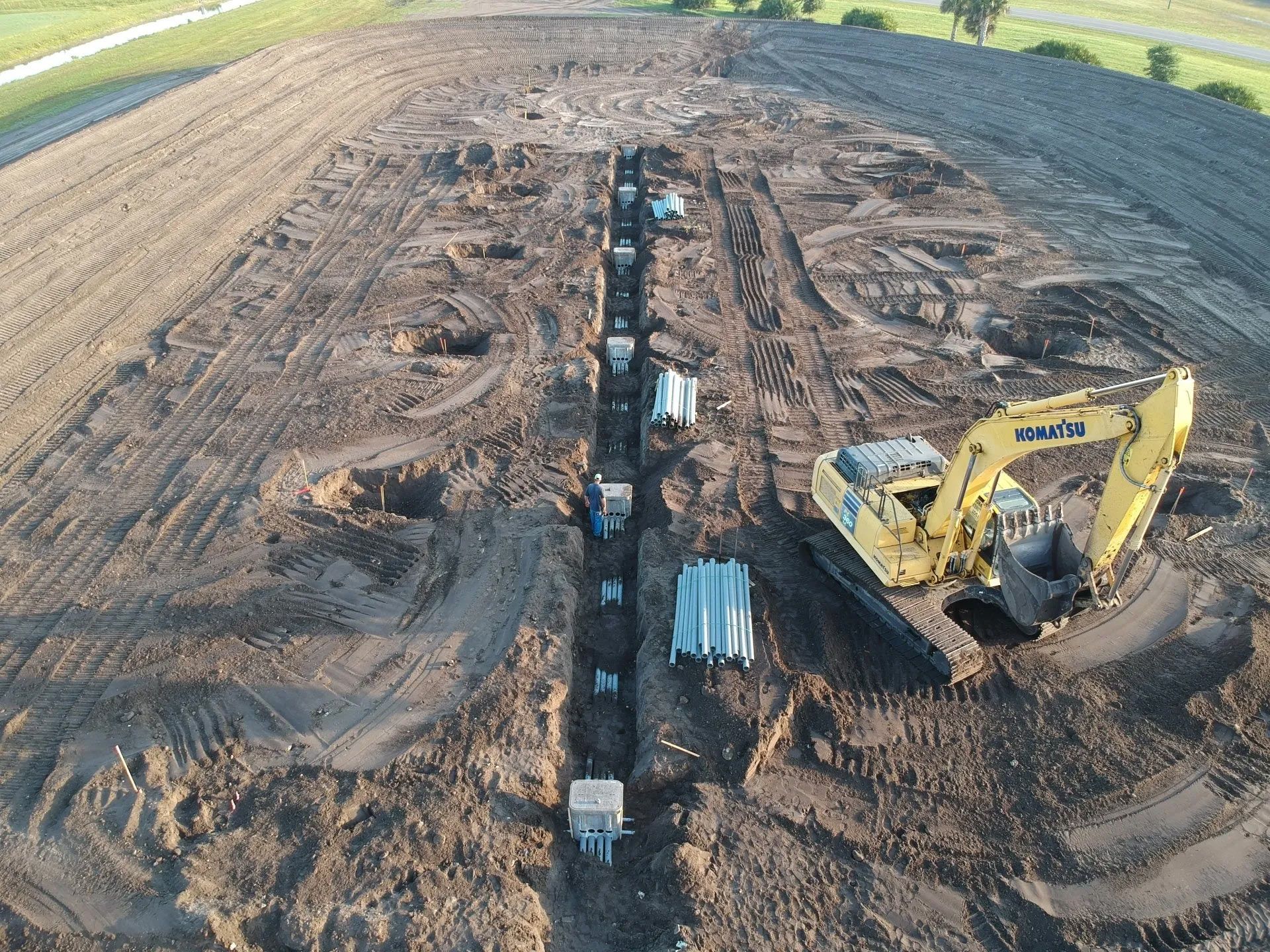 Workers Installing Thin Long Pipes Underground — Clewiston, FL — Ridgdill & Son Workers Installing Thin Long Pipes Underground — Clewiston, FL — Ridgdill & Son