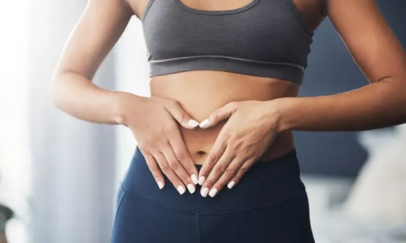 Eine Frau formt mit ihren Händen auf ihrem Bauch ein Herz.